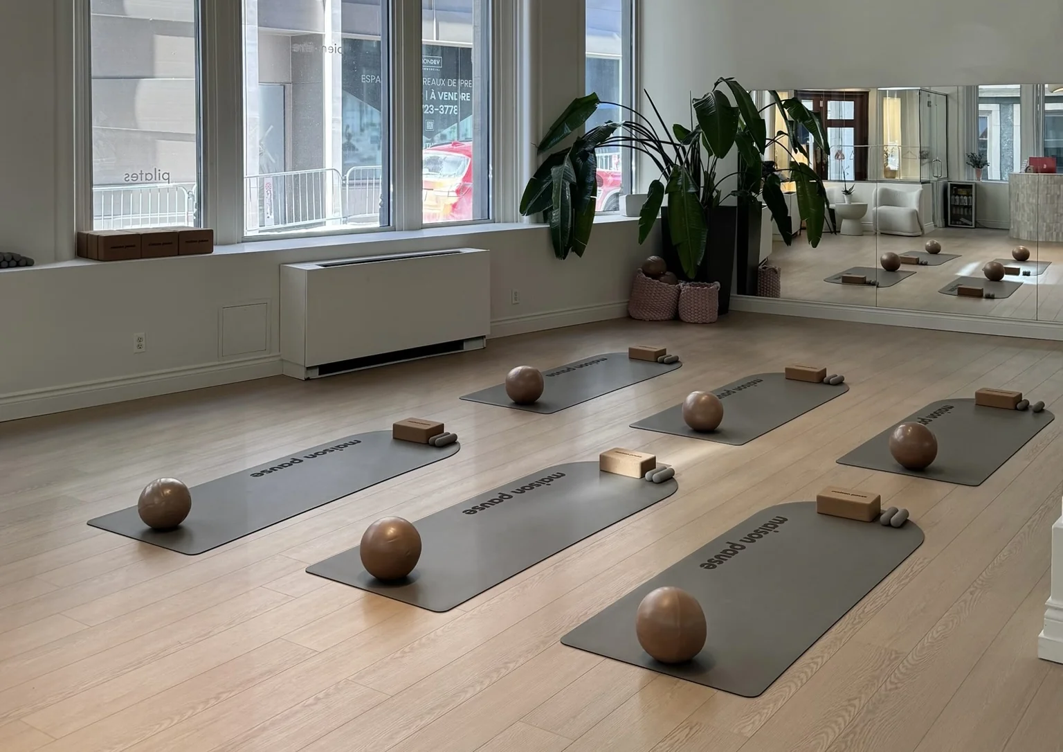 Maison Pause mat studio with branded mats, balls and blocks under tall arched windows